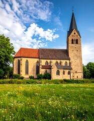 Fototapeta premium Picturesque Church in Rural Landscape Under a Bright Sky.