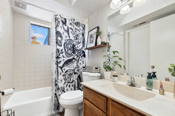 A welldesigned bathroom with a toilet, sink, bathtub, and shower