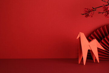 Red origami horse and paper fan composition on red background. Happy Chinese New Year, Year of...