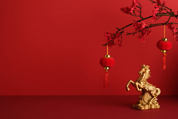 Golden horse statue with hanging lanterns and red flowers for prosperity.