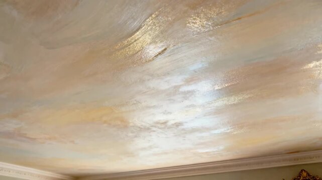 Close medium shot reveals a professional layering glaze for a subtle shimmer on a ceiling emphasizing techniques for a soft elegant variation in ceiling painting.