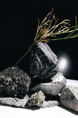 Natural stone and mineral composition arranged in an artistic structure, showcasing raw textures, geological formations and organic surfaces in a minimalist studio setting