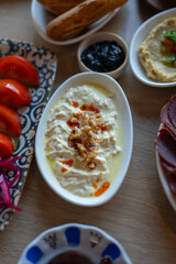 Delicious Turkish Meze Platter With Haydari Yogurt Dip Tomatoes Pastrami Hummus and Bread on a Wooden Table for Restaurant Menus