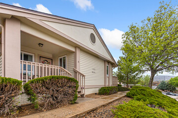 A charming white house with a porch and a tree in front