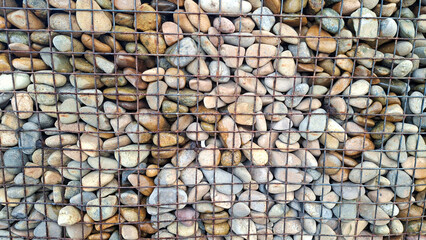 Close Up Of A Gabion Wall Filled With Colorful Smooth River Stones And Pebbles Behind A Wire Mesh Grid
