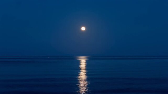 Serene moonlit ocean view with calm water reflecting the night sky in tranquil blue tones