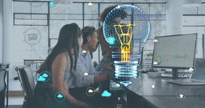 Reviewing charts, team in office wear leaning over monitors at office, hologram bulb and clouds