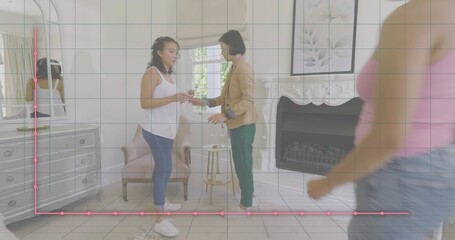 Exchanging object, two women at home by side table, one in tank, other in tan blazer