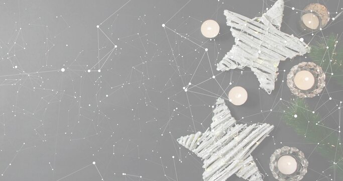 Glowing twig stars and lit tea lights creating cozy holiday scene on gray tabletop, copy space - Powered by Adobe