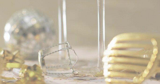 Lying champagne muselet with glass stems creating party table with metal confetti and gold stars