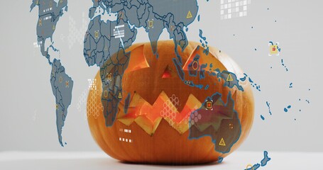 Glowing carved pumpkin casting warm light on white tabletop, with world map overlay and data icons