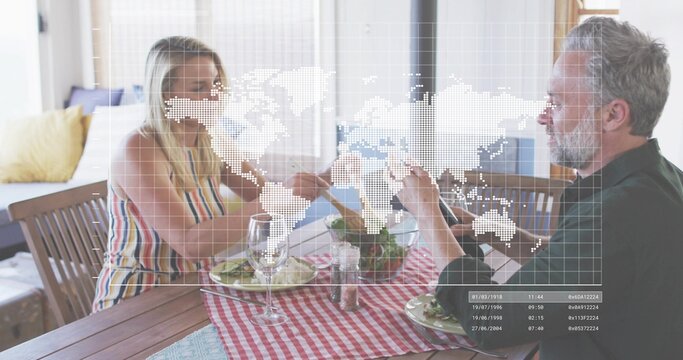 Sitting couple wearing striped dress and dark shirt sharing salad at home table, with map overlay - Powered by Adobe