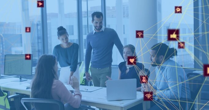 Discussing team wearing business attire around meeting table in modern office, laptop icons