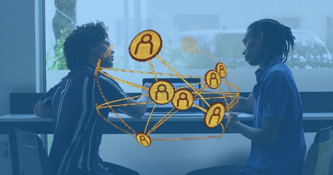 Talking two men in casual shirts discussing project at cafe counter, with laptop network graphic