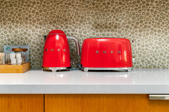 General view of a red and chrome retro-style Smeg Electric Kettle and Toaster on a kitchen countertop.