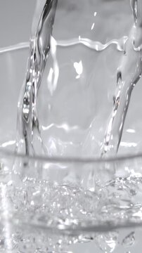 Pouring fresh water into a clear glass with bubbles creating a refreshing atmosphere at home