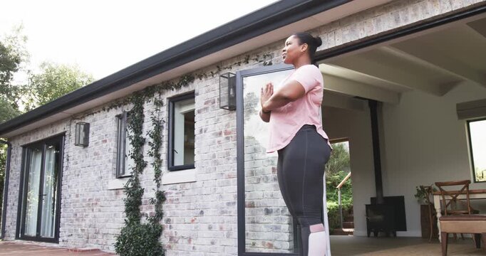 After centering, woman is shifting into warrior pose cobra backbend on brick patio mat for stretch