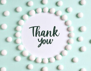 A mint green background is dotted with small white spheres, forming a circle around a white card with the words "Thank You" written in a script font
