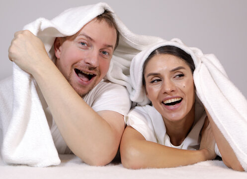 Young happy couple relaxing, lying in bed. Couple in love. Sensual. Bedroom. 