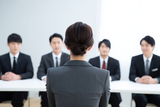 A Professional Woman Preparing for an Important Job Interview in Front of a Panel of Male Interviewers in Suits