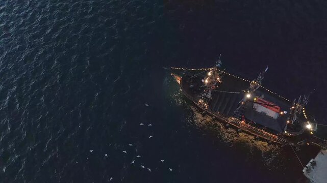 Aerial evening view of floating boat and seagulls along Thessaloniki waterfront