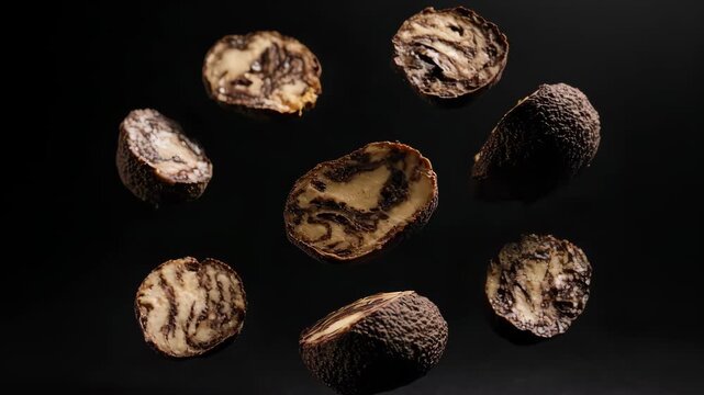 Exotic Marula Fruit: Sliced, Floating, and Revealing Unique Texture on Black Background