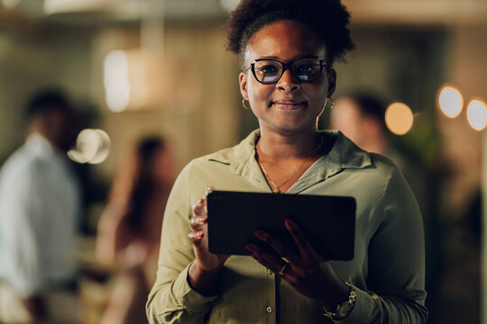 Black businesswoman smiling looking at camera holding tablet