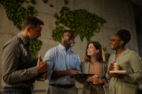 Diverse business team collaborating with tablet in modern office