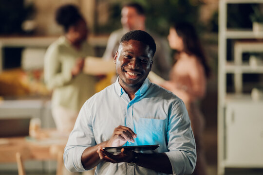African american businessman using digital tablet smiling at office
