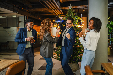 Diverse colleagues celebrating corporate event with karaoke and music