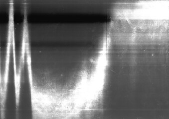 Black and white grunge light leaks background. Abstract distressed monochrome backdrop. Rough film grain surface graphic element.