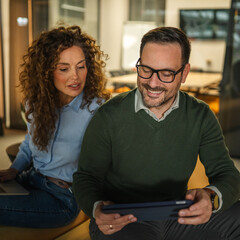 Colleagues collaborating on business project using digital devices