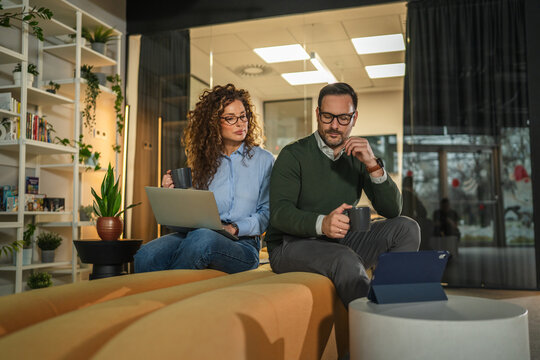 Business colleagues collaborating and discussing ideas in modern office lounge