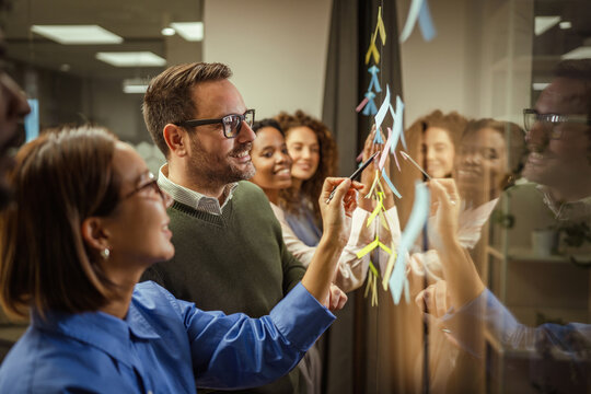 Business team brainstorming ideas on a glass board