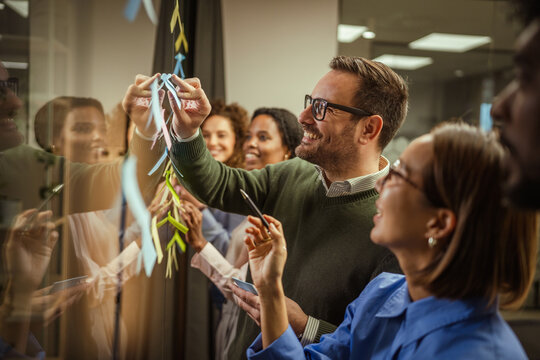 Business team brainstorming ideas on a glass board