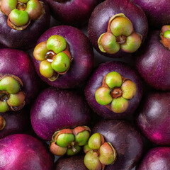 A stack of fresh mangosteens with deep purple rinds and green caps, arranged neatly. Perfect for tropical fruit markets, healthy food themes, and vibrant produce displays.