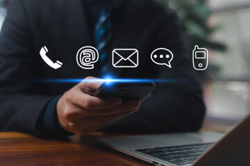 Business communication concept with businessman using smartphone and digital contact icons representing phone, email, chat, and online connection for modern corporate communication.