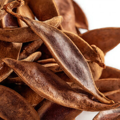 Close-up pile of tamarind pods with textured husks and earthy tones, highlighting their organic shapes. Ideal for food blogs, herbal themes, and traditional cooking visuals.