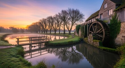 Fototapeta premium Picturesque Cotswold Mill at Sunrise - A Serene Waterscape.