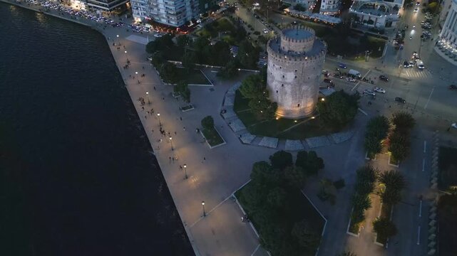 Aerial drone view of White Tower and waterfront, Thessaloniki in the evening