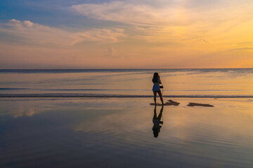 Silhouette woman Traveler Beach Sunrise with Sea Reflections