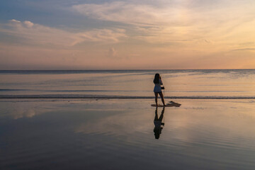 Silhouette woman Traveler Beach Sunrise with Sea Reflections