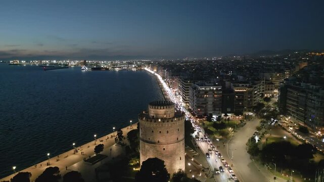 Aerial drone view of White Tower and waterfront, Thessaloniki in the evening