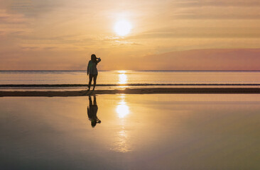 Silhouette woman Traveler Beach Sunrise with Sea Reflections