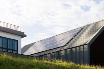 Obraz premium Sustainable Home for Saving Energy, modern house designed with solar panels installed on metal roof sheet, smart home technology for reducing electricity costs. Concept of smart saving.