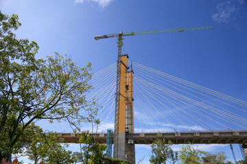 Cable-Stayed Bridge Construction with Tower Crane Under Blue Sky