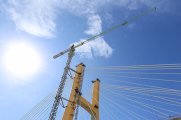 Cable-Stayed Bridge Construction with Tower Crane Under Blue Sky
