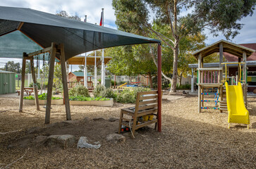 Outdoor kindergarten playground in Australia featuring shaded play areas and natural ground cover. Concept of early childhood education, outdoor learning, safe play environments, community childcare