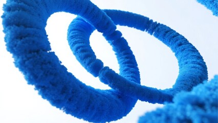 Close-up of intertwined blue fuzzy rings against a light background