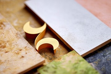Close-up of a gold number six with various tiles in an abstract composition. The image has a shallow depth of field.